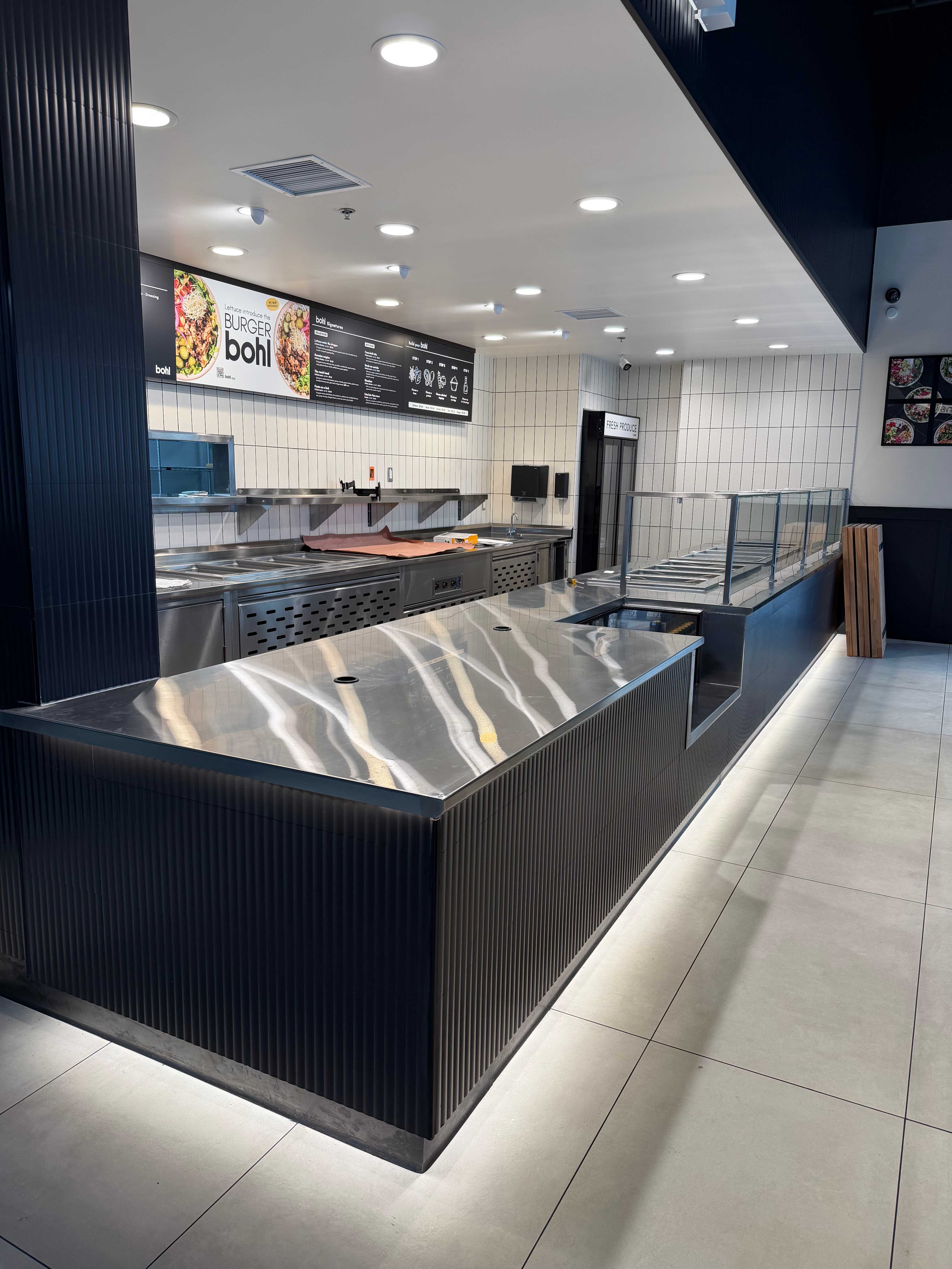 Burger Bohl service counter with stainless steel top and digital menu boards