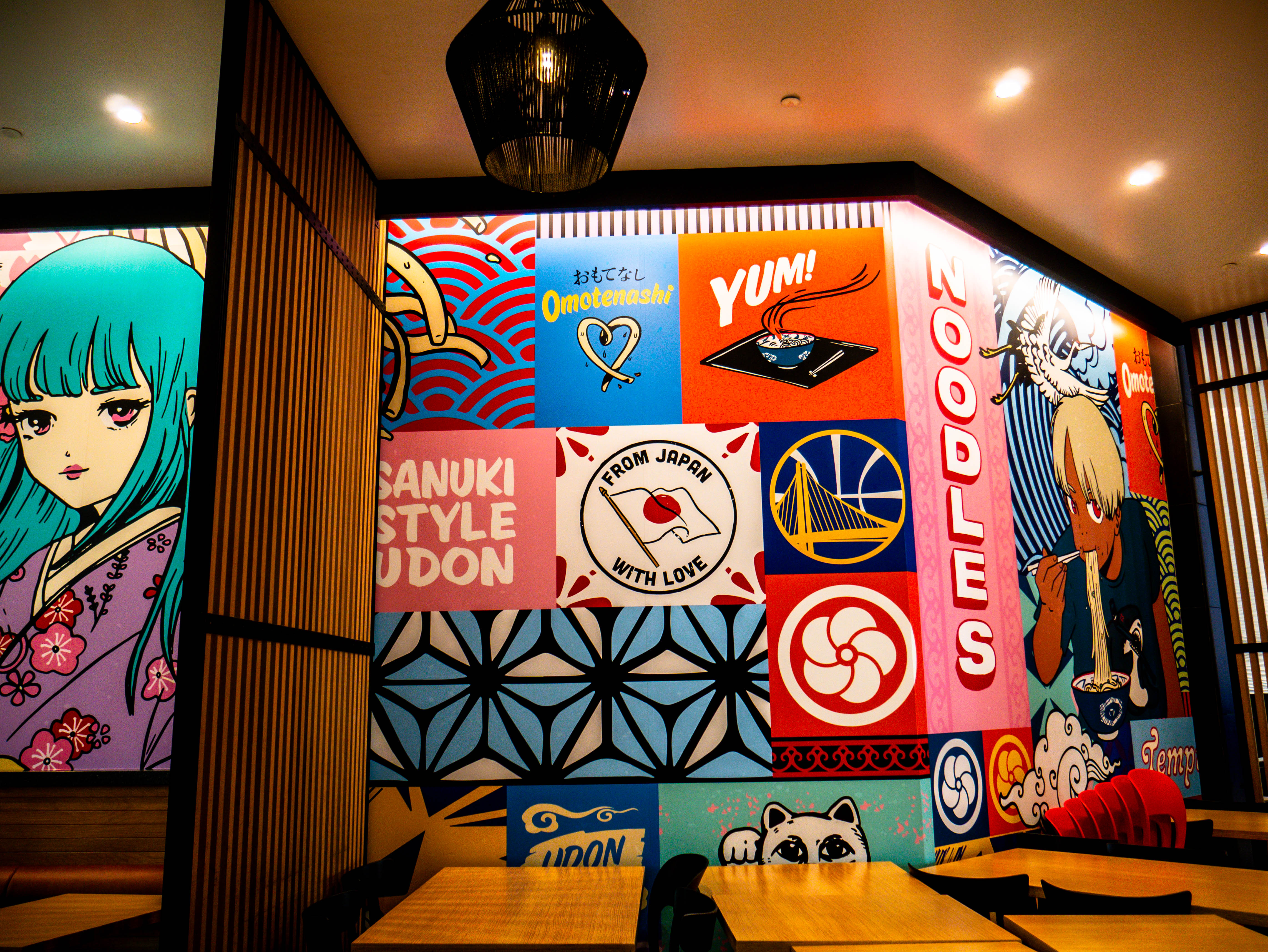 Vibrant wall murals featuring anime characters, Japanese cultural elements, and Golden State Warriors branding