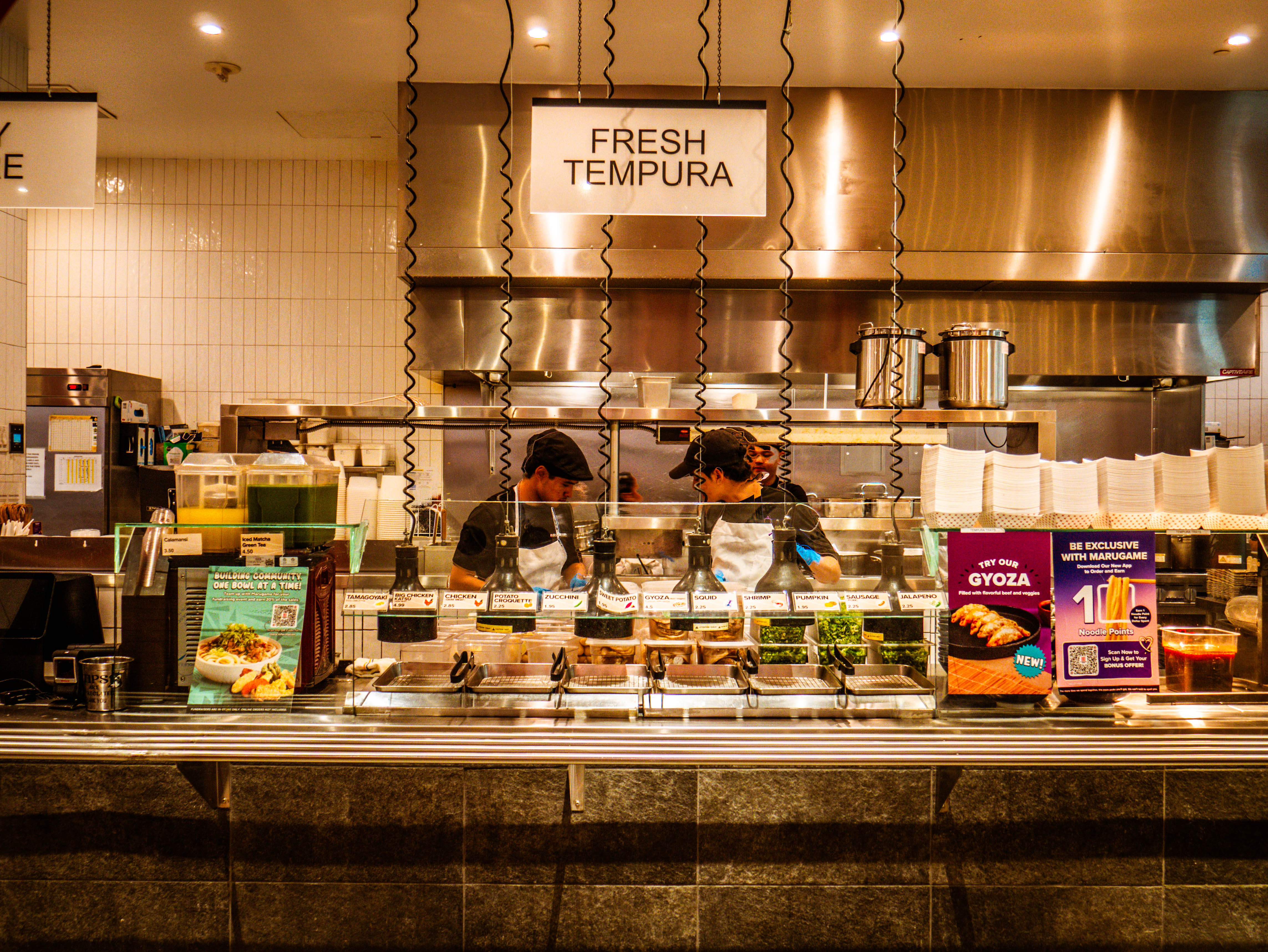 Fresh tempura service station with chefs actively working, ingredient displays, and professional food preparation area