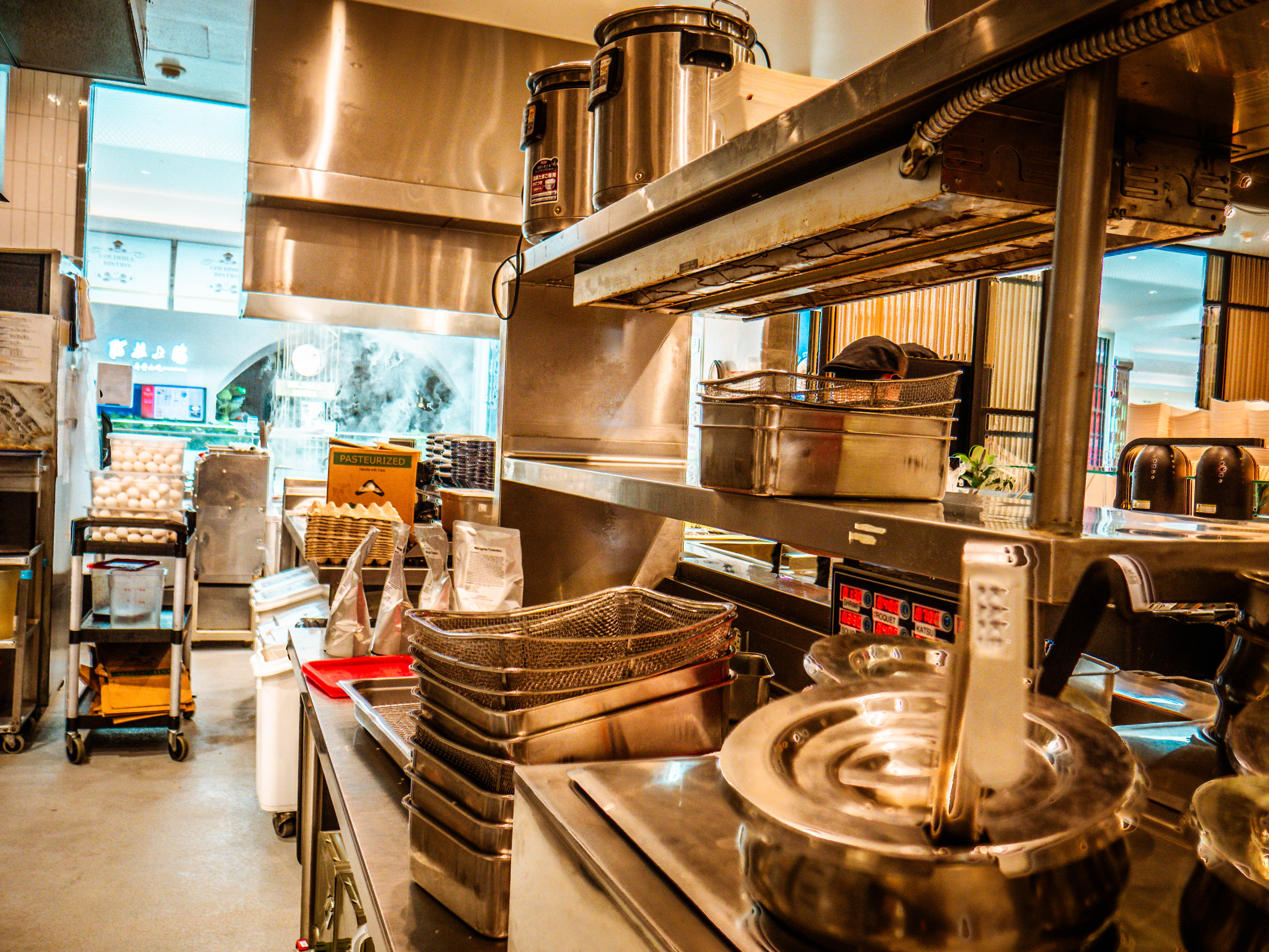 Kitchen storage and prep area with professional equipment, storage baskets, ingredient organization, and comprehensive commercial setup