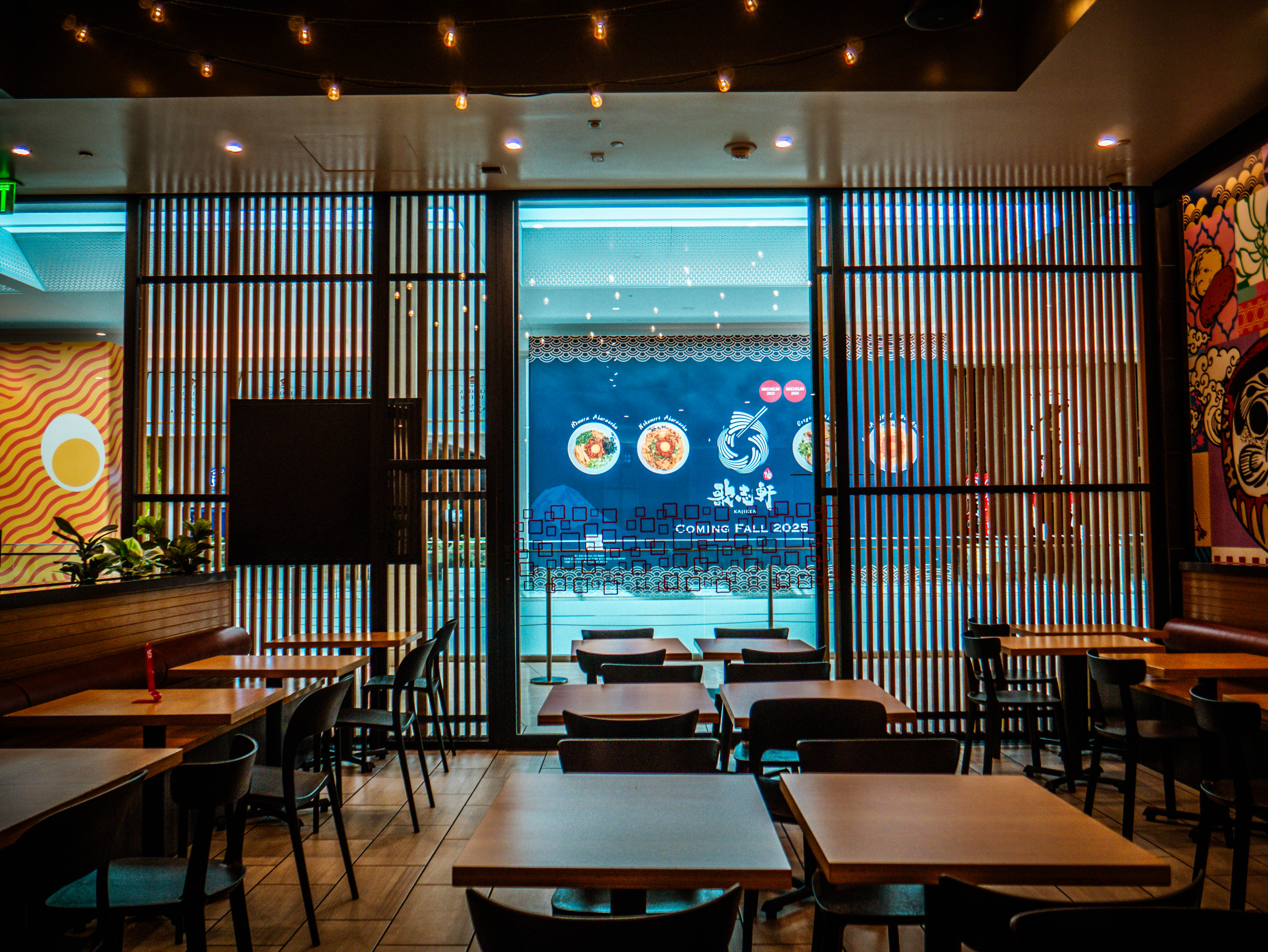 Dining area with wooden slat screens providing privacy while maintaining connection to mall corridor