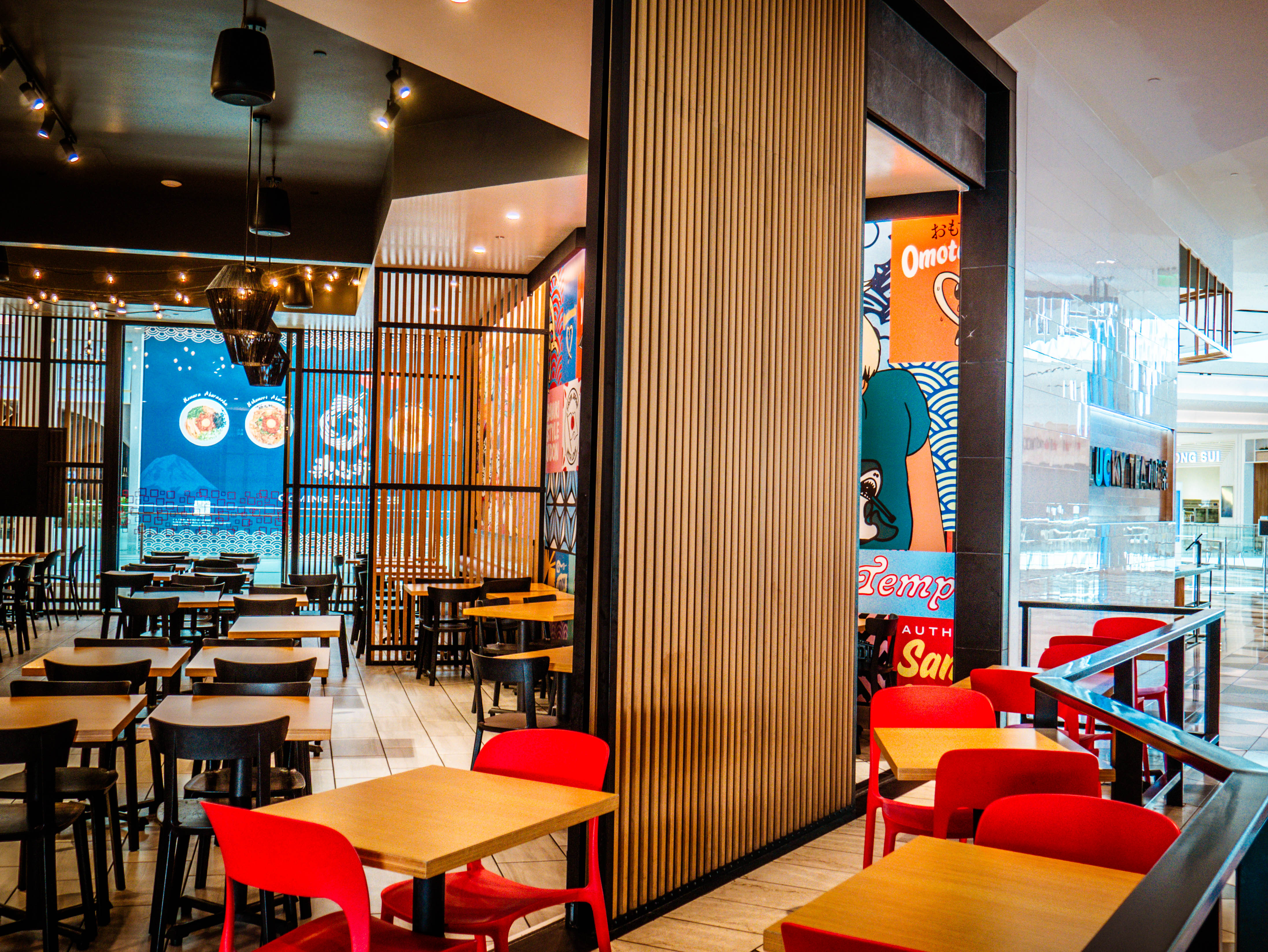 Multi-level dining area showcasing wooden slat architectural elements, red chairs, mall views, and comprehensive seating layout