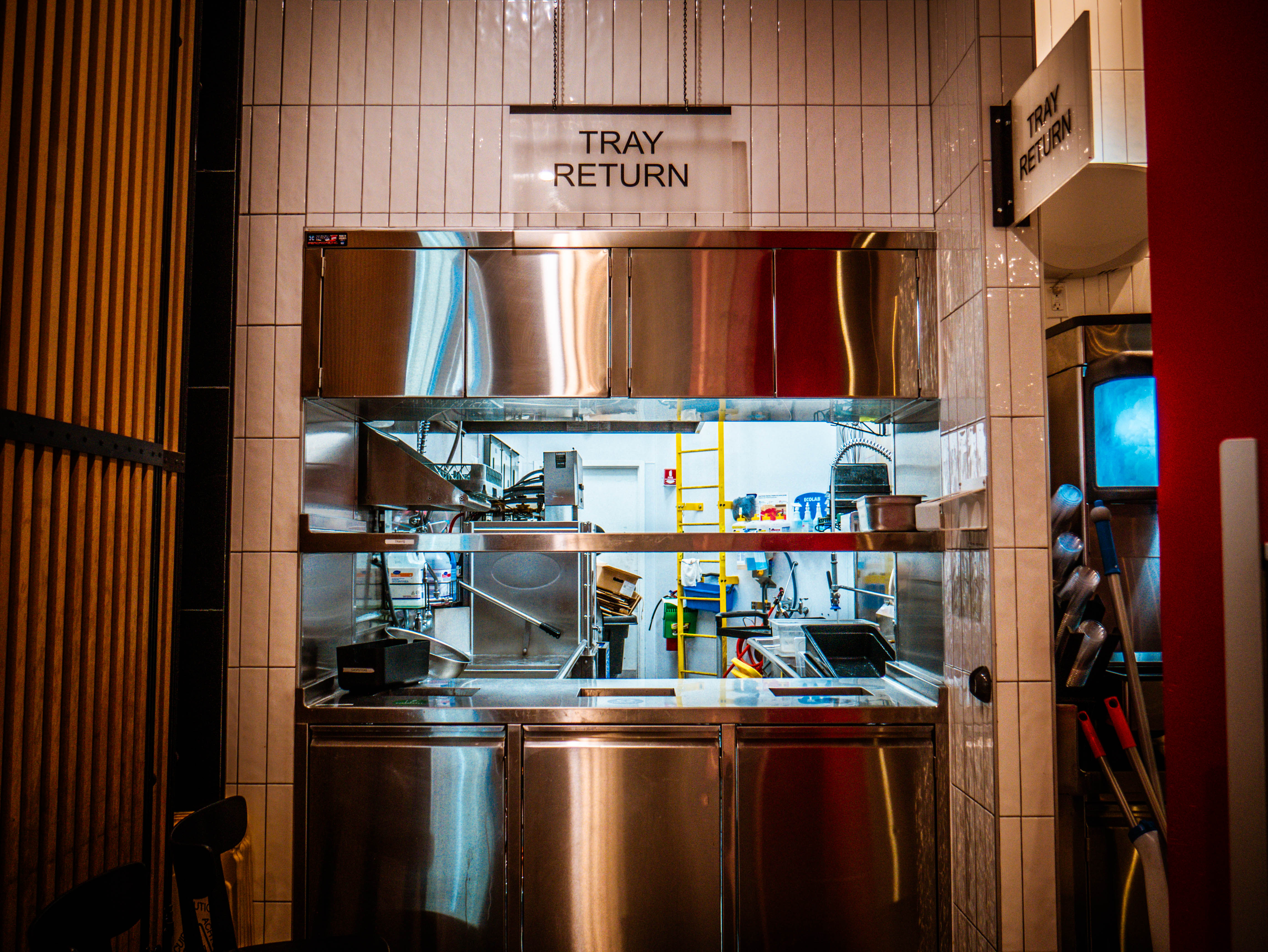 Tray return station with stainless steel equipment and clear view into kitchen operations for efficient service flow