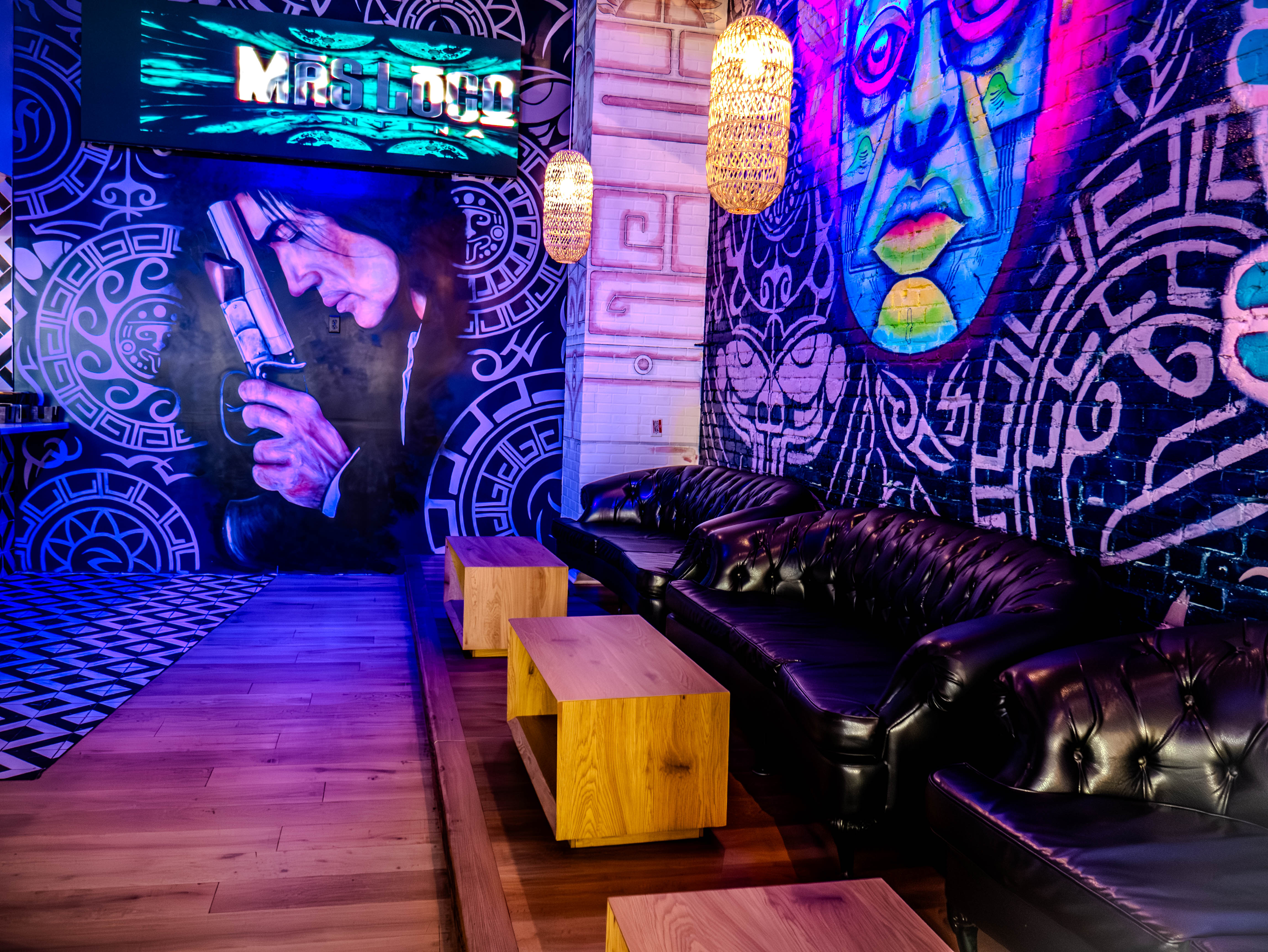 Lounge with dramatic face murals and custom lighting