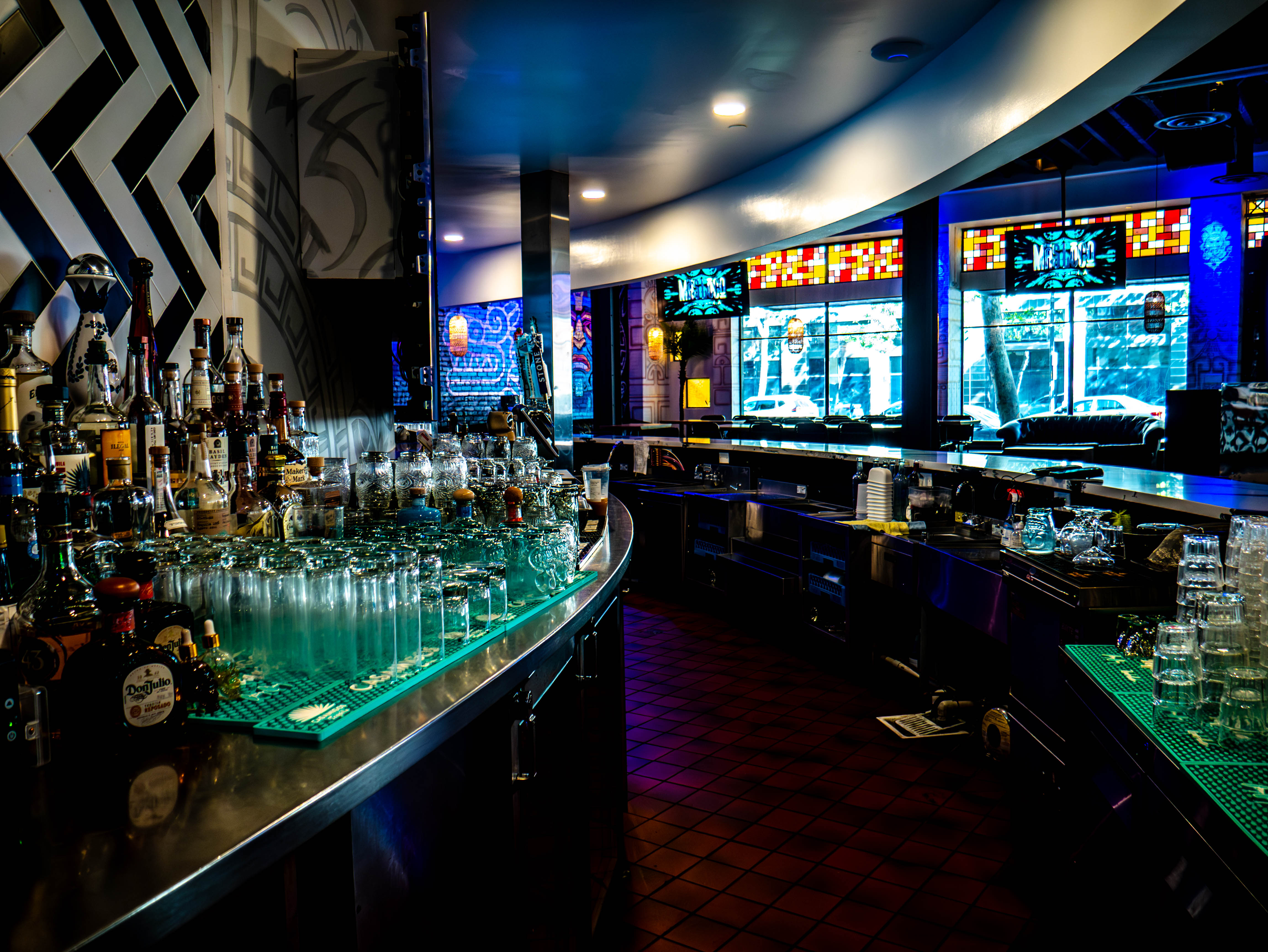 Curved glass bar with extensive liquor display and modern commercial design