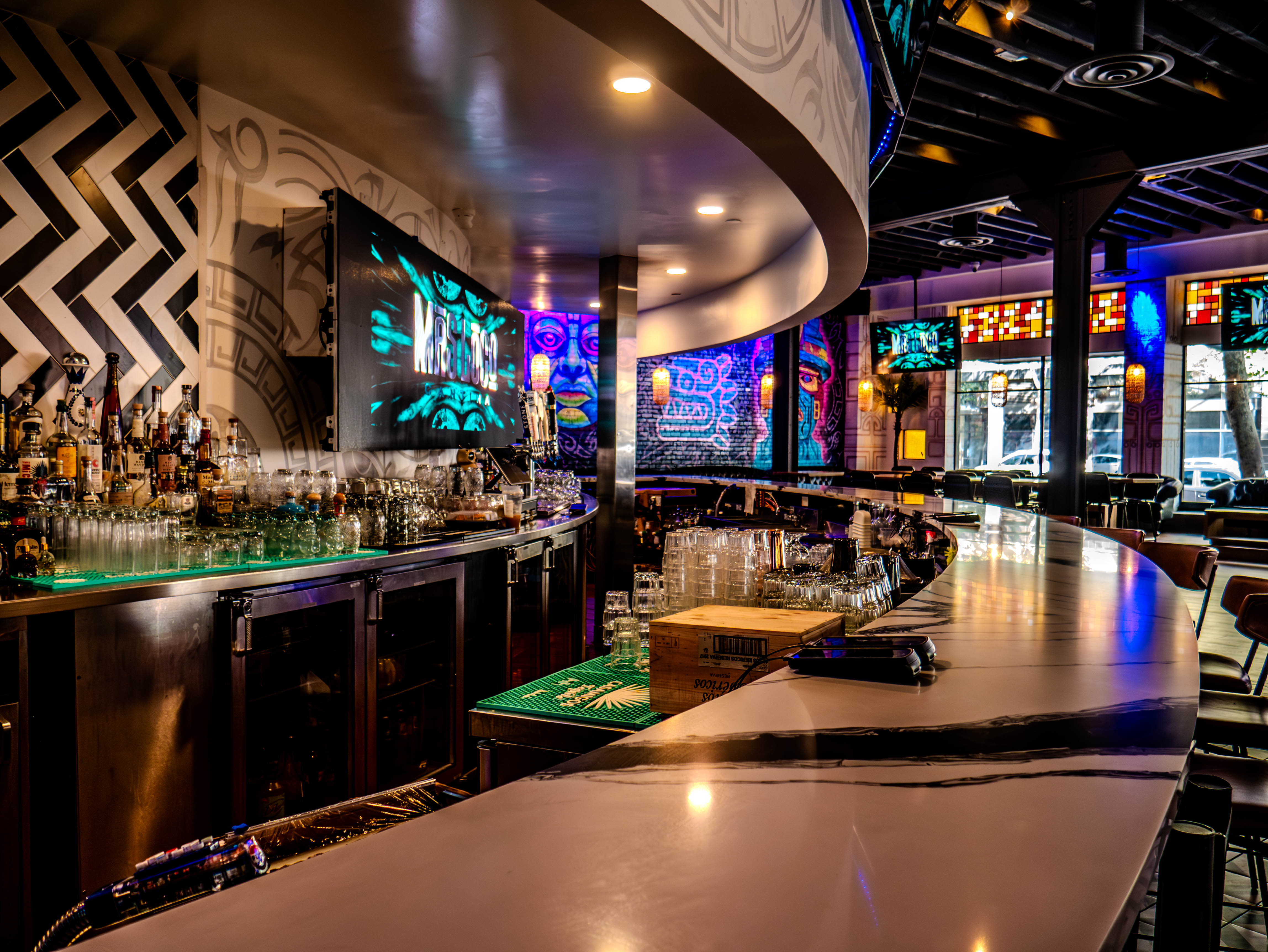Detailed view of curved main bar with extensive liquor display and professional equipment