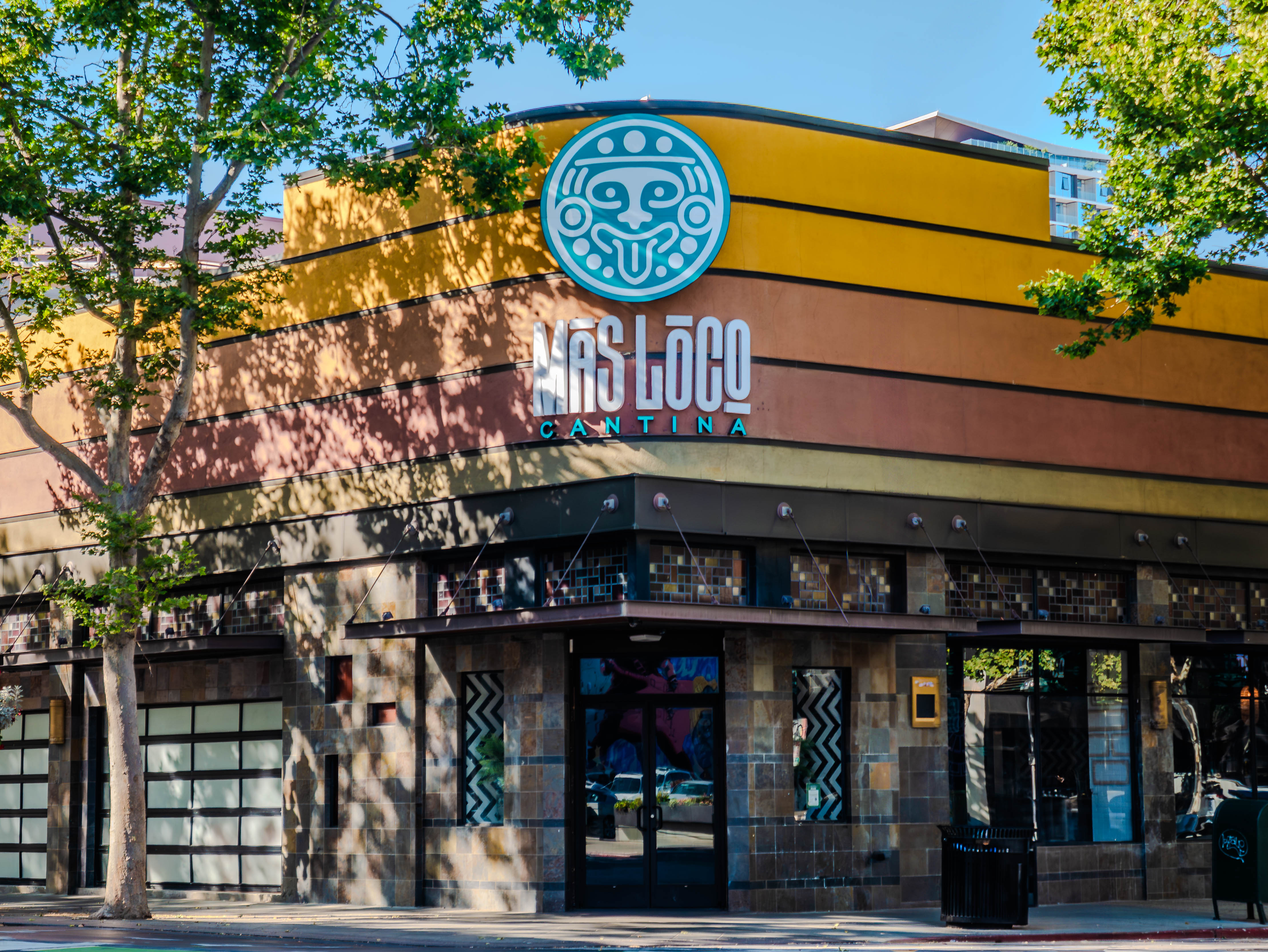 Mas Loco Cantina exterior with distinctive yellow and brown facade
