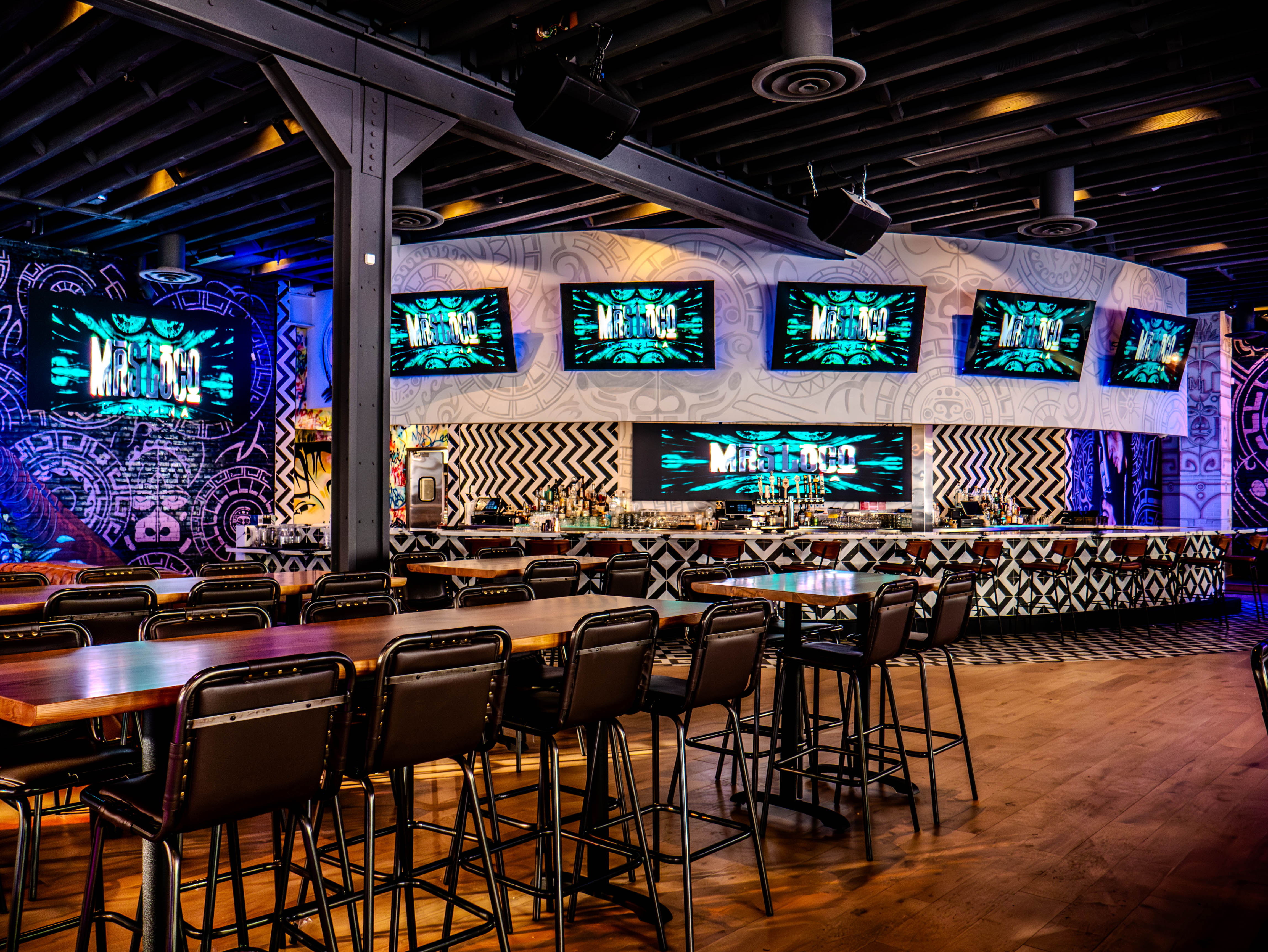 Main bar area with extensive TV screen installation and curved white ceiling design