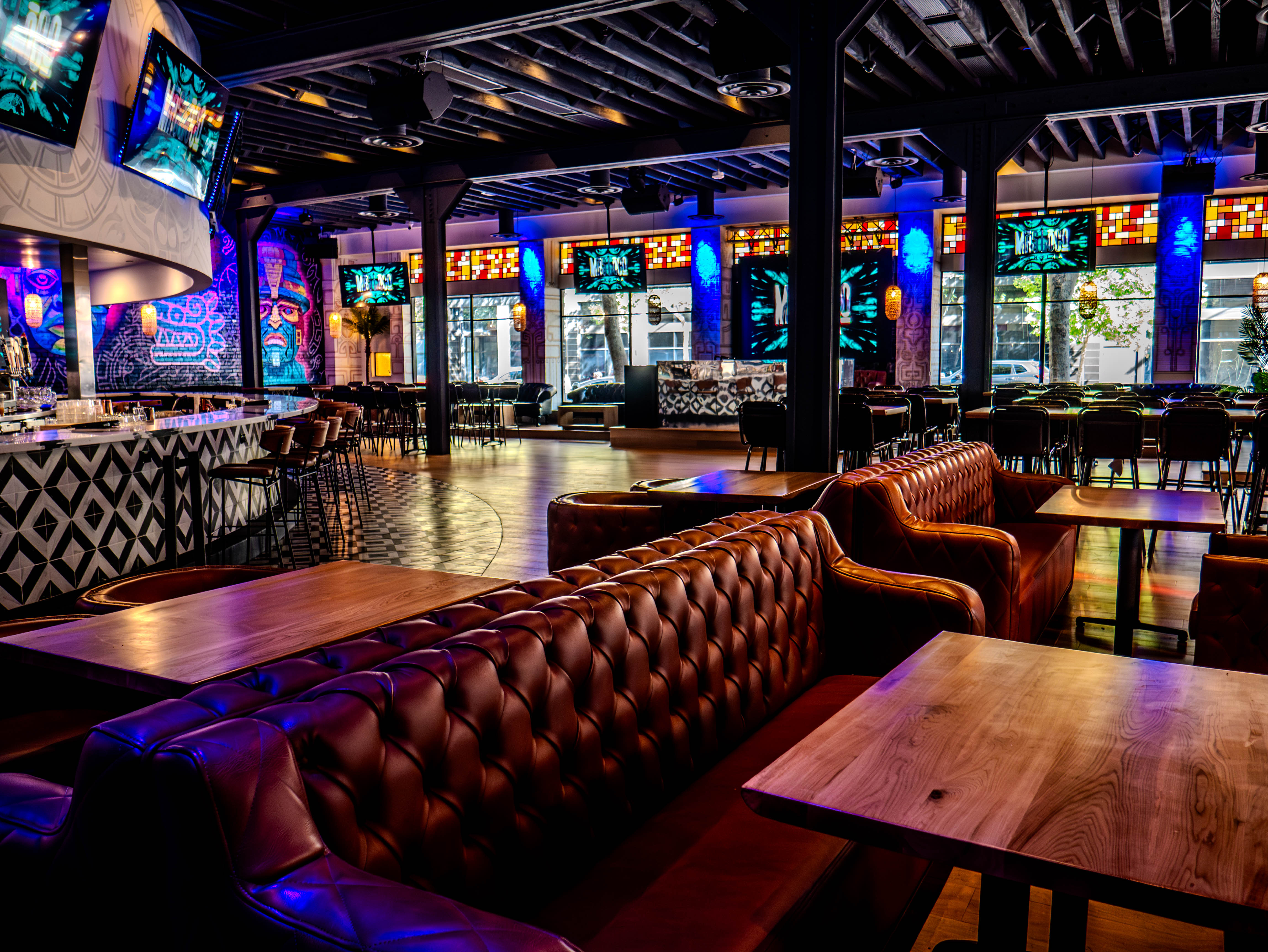 Mas Loco Cantina luxurious main dining area with brown leather tufted banquettes