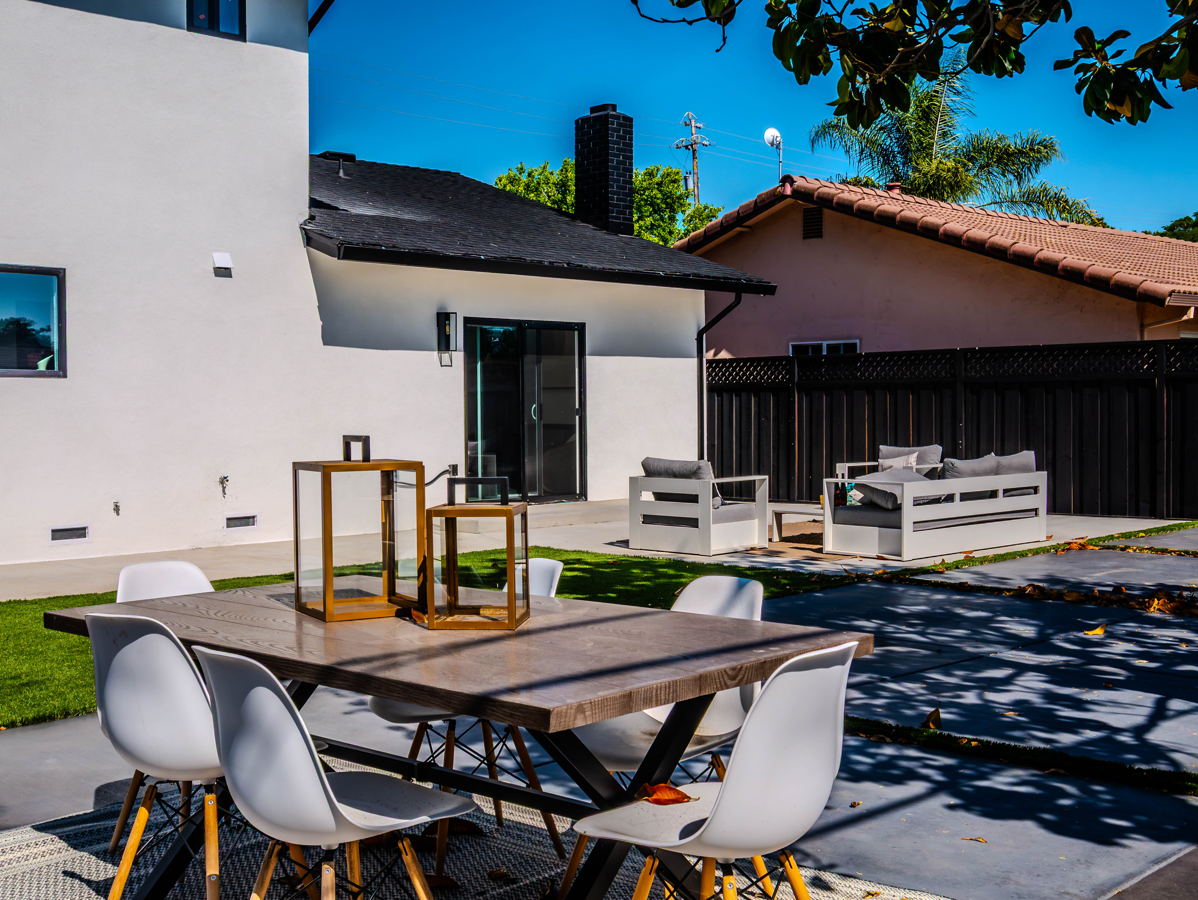 Outdoor dining area with modern furniture, lawn, and integrated landscape design