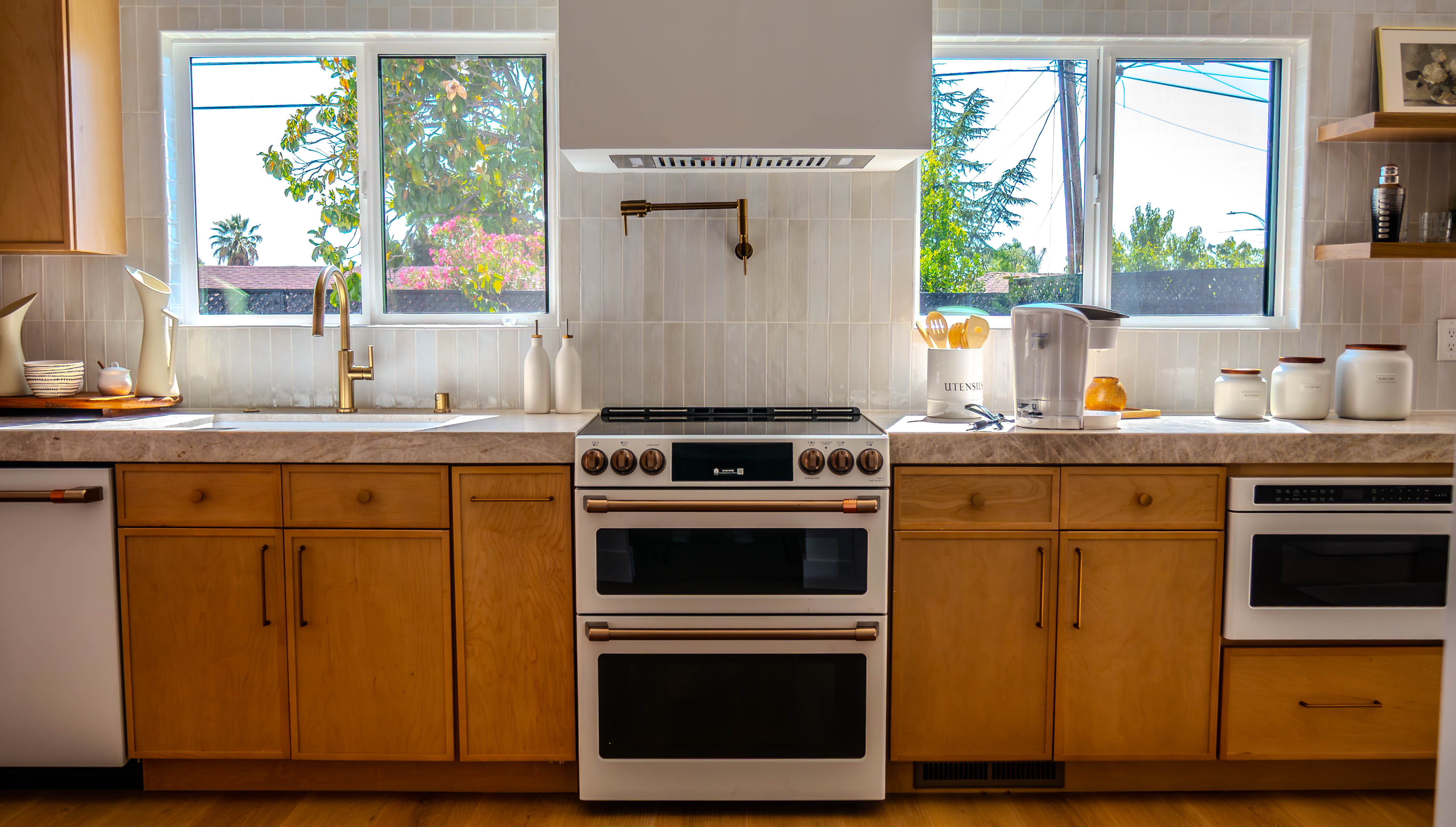 Close-up of premium kitchen featuring wooden cabinetry, vertical tile backsplash, and stainless steel appliances