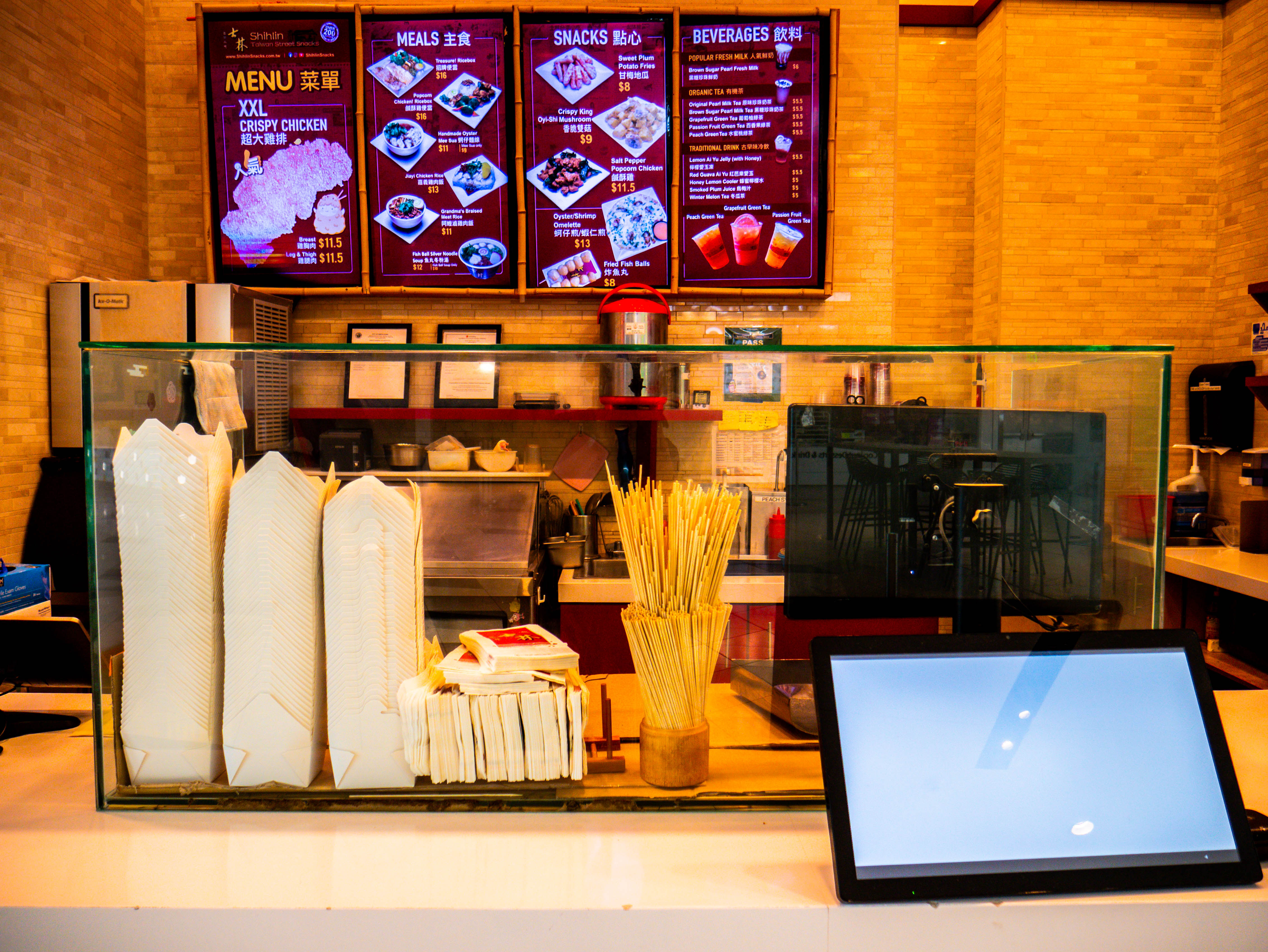 Detailed view of service counter with POS systems, menu boards, and professional customer service setup